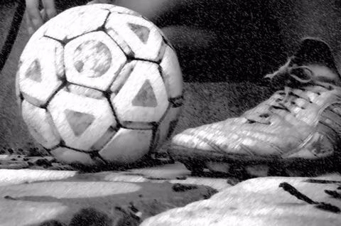 Alter Lederball und Fussballschuh in Schwarzweiß