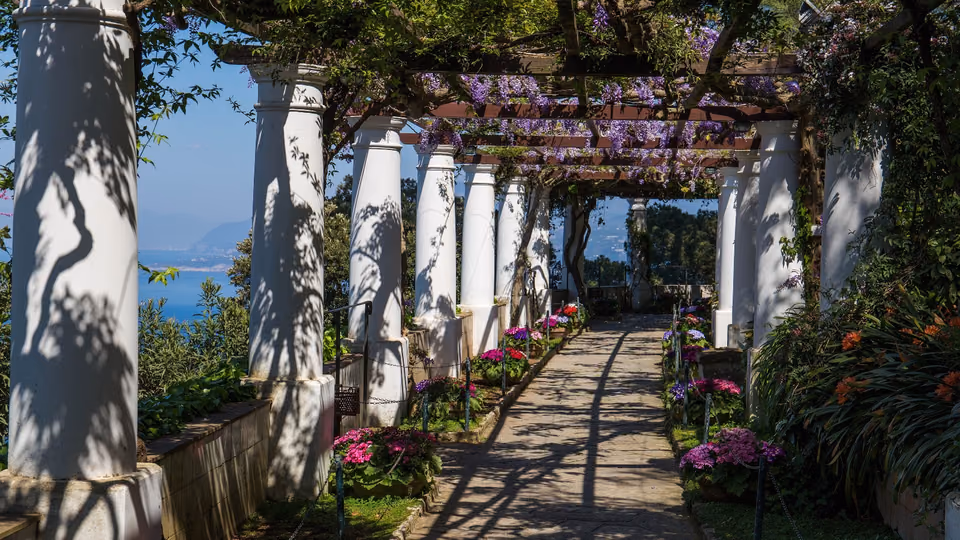 Pergola mit weißen Säulen und blühenden Pflanzen im Garten der Villa San Michele auf Capri