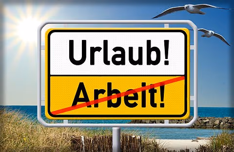 Ortsschild mit den Worten Urlaub und durchgestrichen Arbeit vor dem Meer